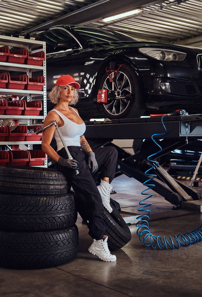 Serious female worker at busy auto service - Foto, imagen