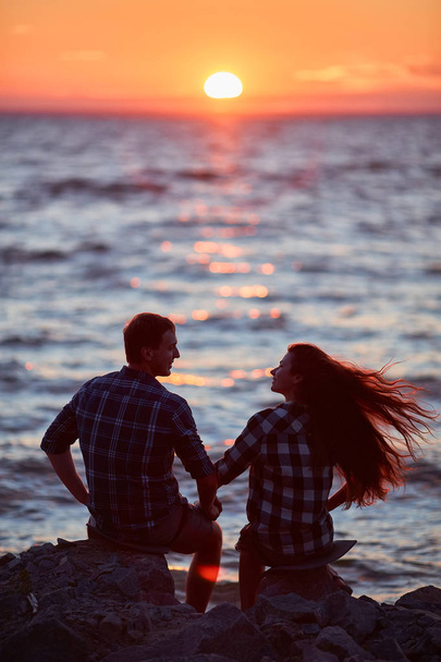 Un couple tenant la main pendant un coucher de soleil
 - Photo, image