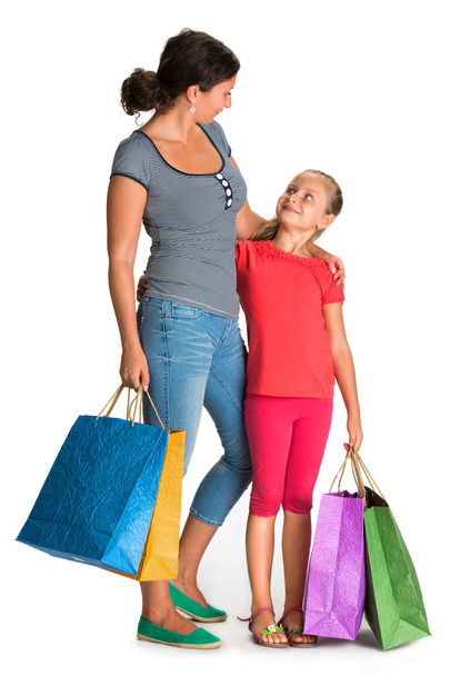 lachende moeder en dochter met shopping tassen - Foto, afbeelding
