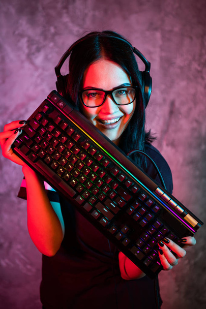 Αστείο φυτό κορίτσι φορώντας γυαλιά μεταφέροντας το πληκτρολόγιο του υπολογιστή - Φωτογραφία, εικόνα