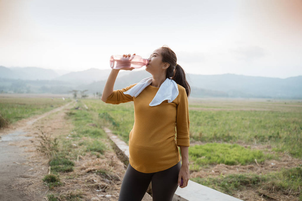 pregnant woman drink water bottle while workout - Fotografie, Obrázek