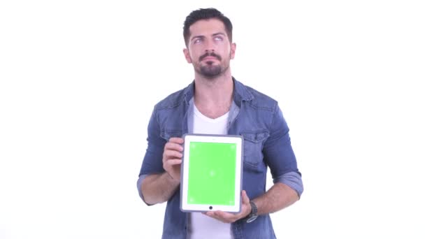 Heureux jeune homme barbu hipster penser tout en montrant tablette numérique - Séquence, vidéo