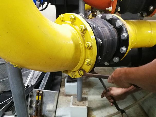 The technician tightens the bolts on the Rubber Expansion Joint with a wrench - HVAC Flexible connector. - Photo, Image