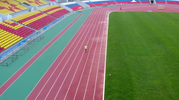 A man runs on a treadmill at the stadium. Summer time - Footage, Video