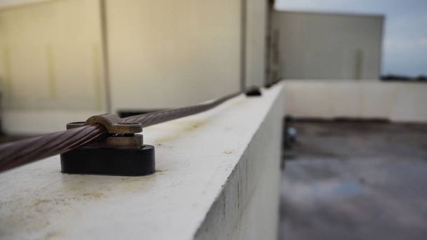 Zbliżenie z miedzi i siodełka kablowe ochrony odgromowej na dachu - Zdjęcie, obraz
