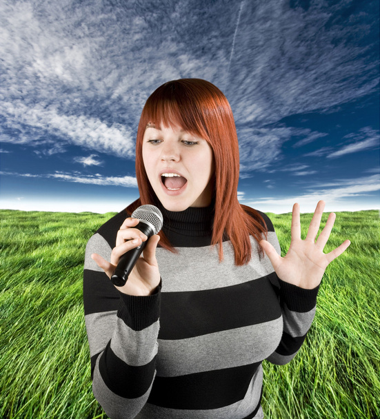 Redhead girl singing karaoke on microphone - Photo, Image