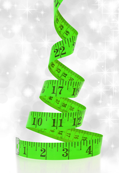 Concepto de dieta navideña. Árbol de Navidad hecho de cinta métrica
 - Foto, imagen