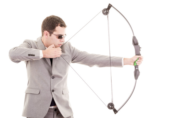 Determined handsome businessman aiming at target with bow - 写真・画像