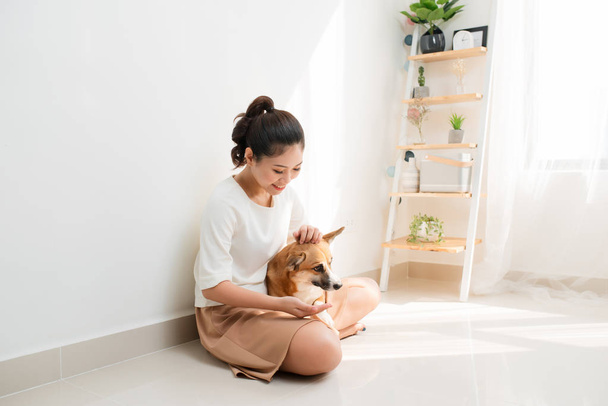 Atraente jovem mulher asiática com seu cão Corgi em casa
 - Foto, Imagem