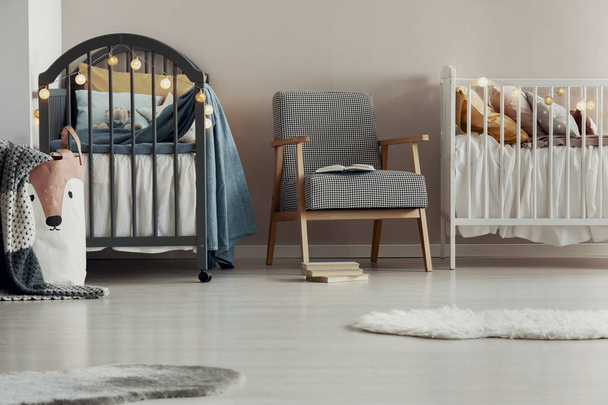 Stylish vintage armchair in the middle of cute baby room for twins - Фото, зображення