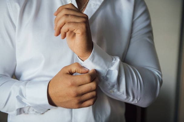 Man buttons cuff link on cuffs sleeves luxury white shirt. - Foto, Imagem