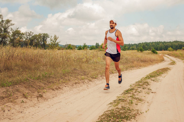 Мужчина бежит на улице с бородой в спортивной форме на природе, днем, на открытом воздухе
 - Фото, изображение