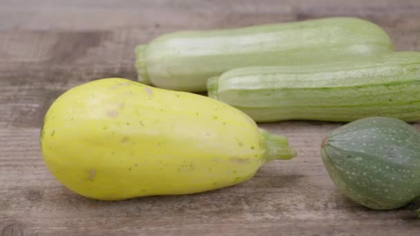 Zucchini různých odrůd a typů je na starém dřevěném pozadí. Close-up. - Záběry, video