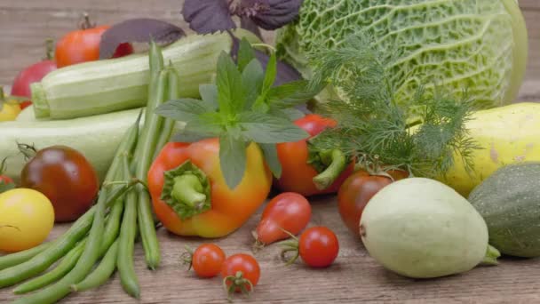 Vegetable mix. On the table are various vegetables and greens. On a wooden background. - Footage, Video