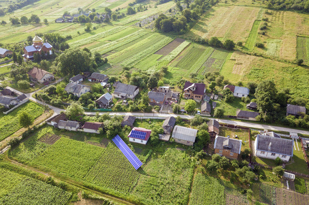 クリーンエネルギーのための青いソーラーパネルを持つ家の航空写真. - 写真・画像