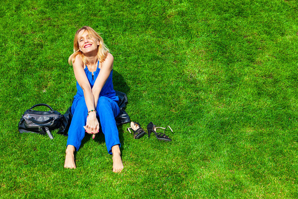 Happy woman sitting on green grass - Foto, Bild