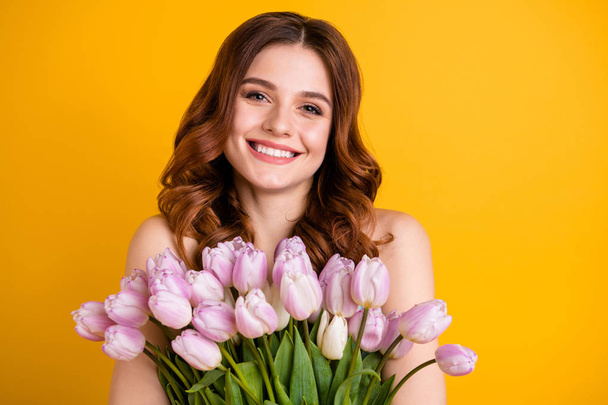 Close up photo of amazing lady holding big bunch of pink tulips in hands isolated yellow background - Photo, Image