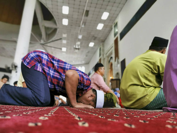 An out of focus image of an unidentified Muslim man in prostration (sujod) during a prayer (solat) session. - Foto, imagen