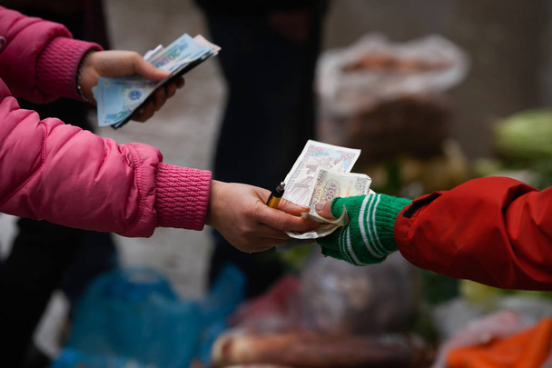 Вьетнамские женщины-торговцы считают банкноты на местном рынке
. - Фото, изображение