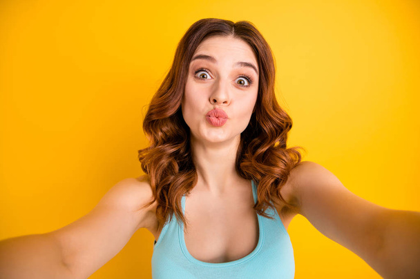 Photo of lady making selfies sending instagram followers air kisses wear tank-top isolated yellow background - Photo, Image