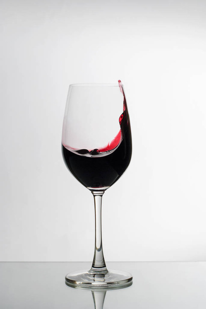 ワイングラスの側面に赤ワインが飛び散る - 写真・画像