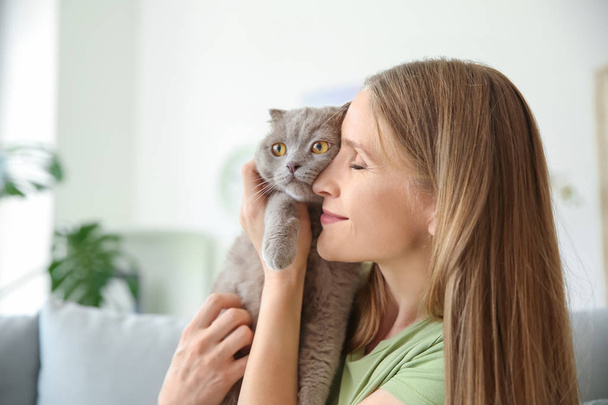 Gyönyörű nő aranyos macskával otthon - Fotó, kép