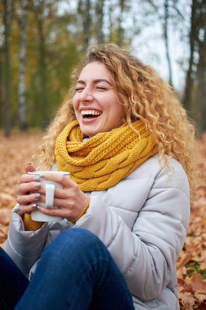 Menina situada nas folhas de outono, relaxando e apreciando a vista
 - Foto, Imagem