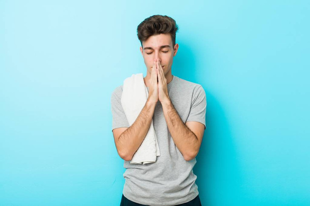 Mladý fitness teenager, který drží ruce v modlení se blízko úst, je přesvědčen. - Fotografie, Obrázek