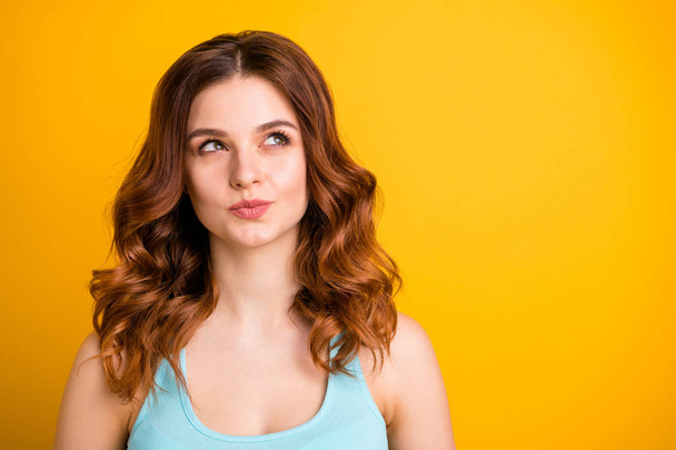 Photo of charming attractive nice cute interested girlfriend wearing teal singlet thinking on something sly while isolated over yellow background - Photo, Image