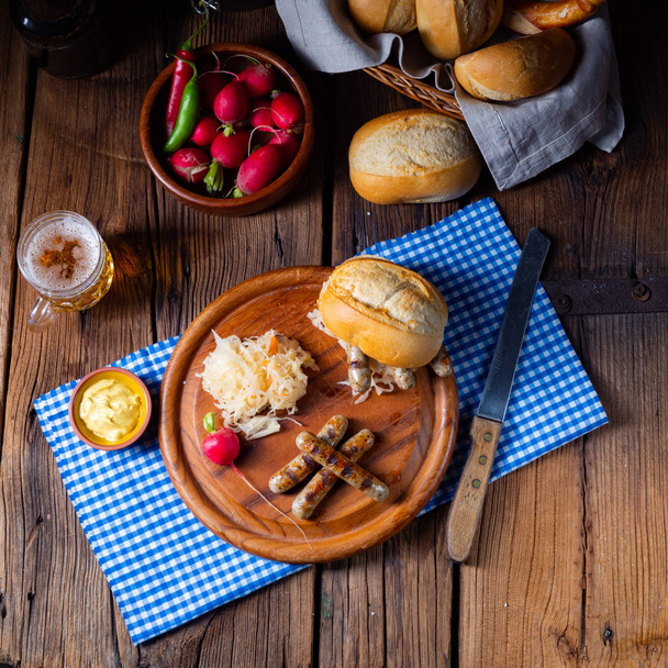 ρουστίκ Θουριγγίας bratwurst με λάχανο τουρσί και ρολό - Φωτογραφία, εικόνα