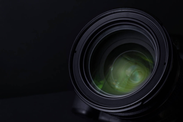 Lens of professional camera on black background, closeup - Foto, afbeelding