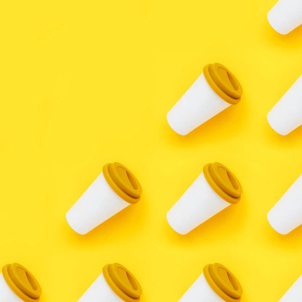 White bamboo coffee to go cups with a yellow rubber lid on a yellow background. Diagonal isometric view. Flat lay - 写真・画像
