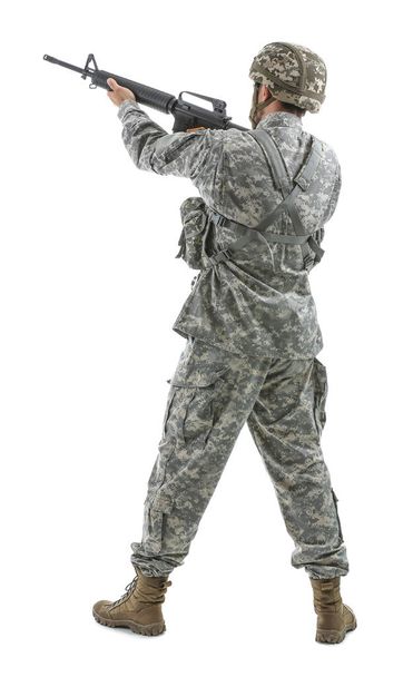 Soldier in camouflage taking aim on white background, back view - 写真・画像