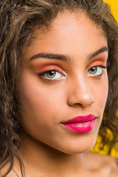 Primer plano de una joven afroamericana hermosa y maquilladora posando
 - Foto, Imagen