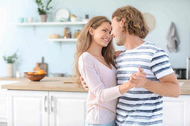 Happy young couple dancing in kitchen - 写真・画像
