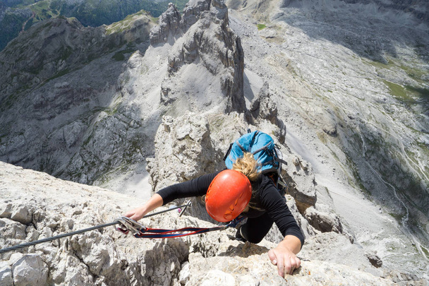 ελκυστική ξανθιά γυναίκα ορειβάτη σε μια απότομη Via Ferrata στο I - Φωτογραφία, εικόνα