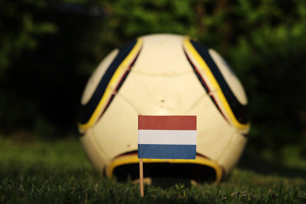 Staat symbool van Nederland gestoken in speeltuin en in de achtergrond Soccer Ball voor beter looks. Wereldkampioenschap 2022. Euro 2020. International match - Foto, afbeelding