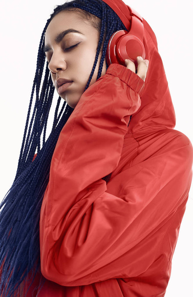 African teenage girl with dreadlocks in red windbreaker listenin - Zdjęcie, obraz