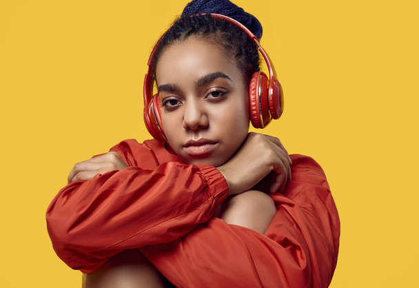 African teenage girl with dreadlocks in red windbreaker listenin - Photo, Image