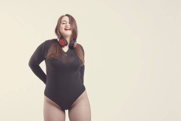 Model plus size with sweet donut, happy girl posing with headpho - Photo, Image