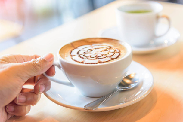 Take the hot coffee on table / hot cappuccino with nice pattern milk foam  - Foto, immagini