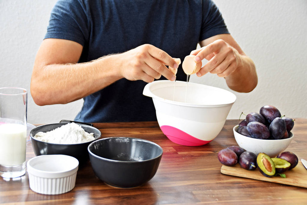 cropped image of man preparing plum baking at kitchen - Valokuva, kuva