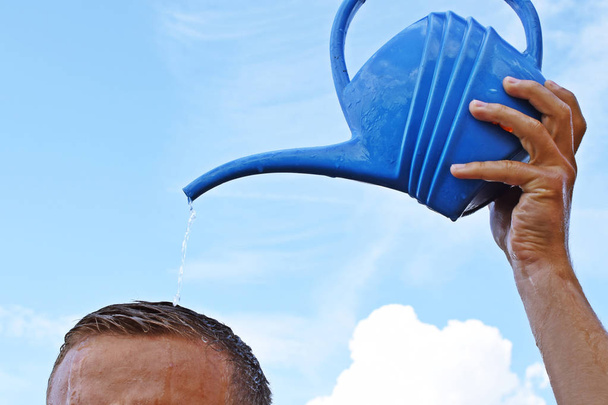 cropped image of man pouring water from watering can on his own head - Photo, Image