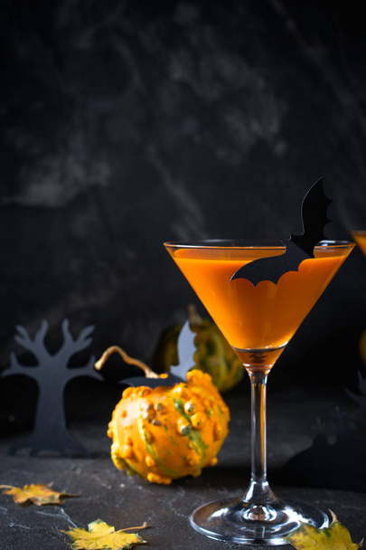 Calabaza naranja, bebida de Halloween para la fiesta y decoraciones navideñas sobre fondo negro con espacio para copiar
 - Foto, imagen