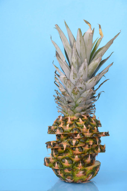 Together, slices of a pineapple make up a whole pineapple in front of a solid background with space for text or objects - Foto, Bild