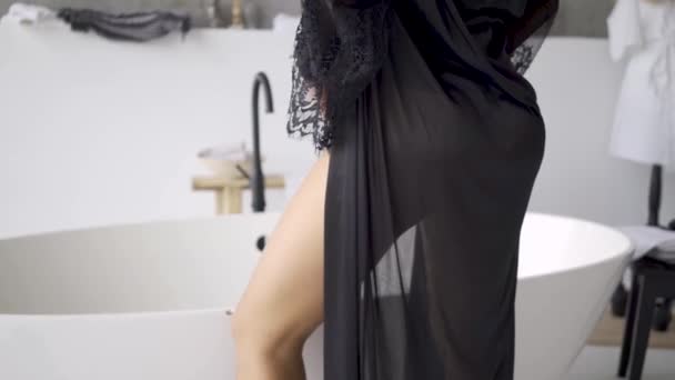 Unrecognizable young woman in beautiful elegant clothes with slim body standing the bath in the bathroom. The girl preparing for the date - Felvétel, videó