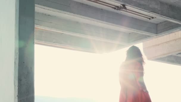 Μοναχικό κορίτσι με κόκκινο μπουφάν που περπατάει και βλέπει το ηλιοβασίλεμα πάνω από το δάσος - Πλάνα, βίντεο