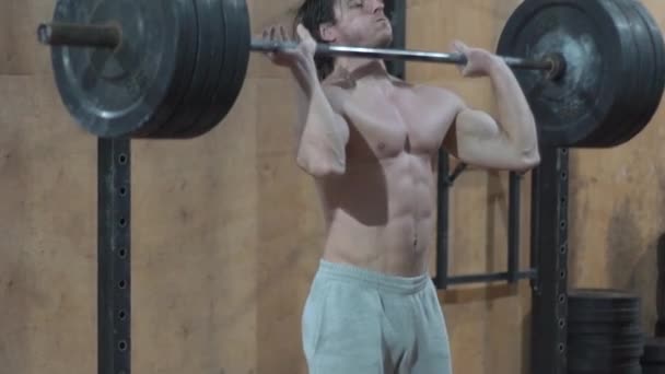 handsome guy, athlete, weightlifting, training in crossfit gym, lifting barbell - Záběry, video