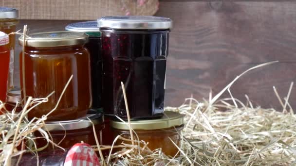 Moving camera slider showing  jars with different kinds of jam on straw - Filmmaterial, Video