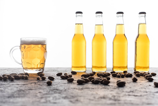 mug with beer near bottles and coffee grains on brown textured surface - 写真・画像